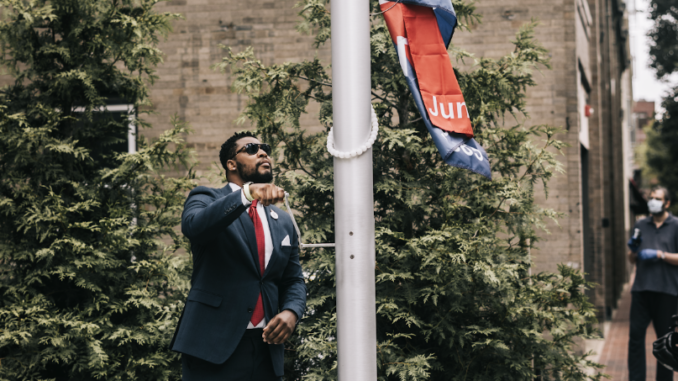 Malden CORE member Ted Louis Jacques raising the Juneteenth Flag at City Hall Plaza