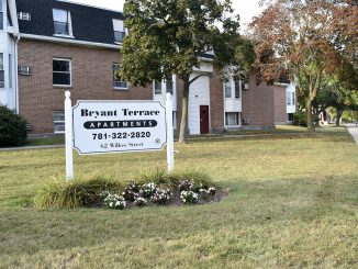 Bryant Terrace Apartments sign with phone number and 62 Willow St. address, in front of apt buildings.