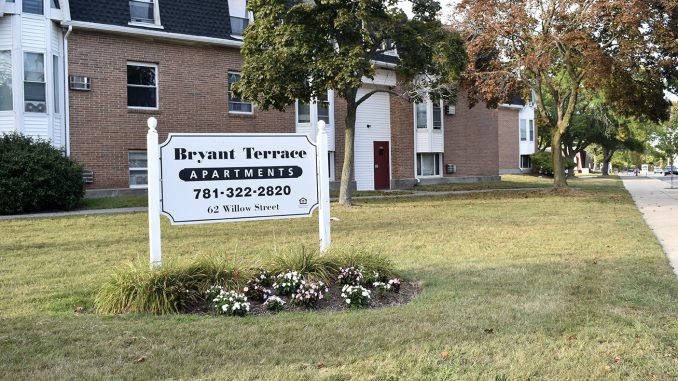 Bryant Terrace Apartments sign with phone number and 62 Willow St. address, in front of apt buildings.